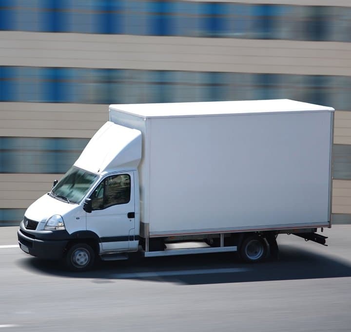 Yolda hareket halindeki beyaz kapalı kasa minivan