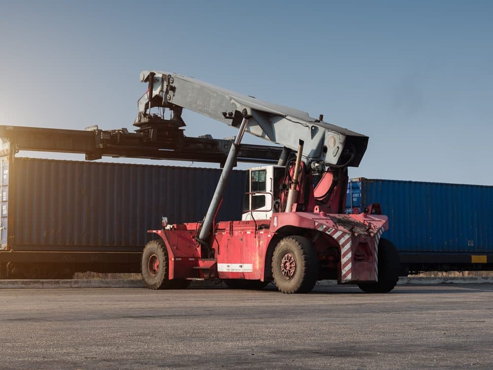 Demiryolu vagonuna konteyner yükleyen reach stacker